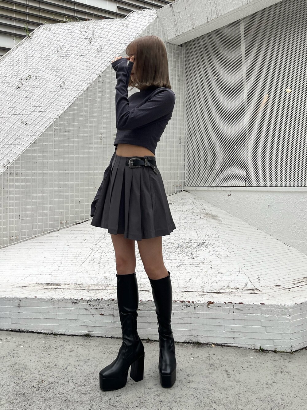 グレー系のスカート、グレー系のTシャツ/カットソー、ブラック系のムートンコートを着用したレディースの秋コーディネートの4枚目の写真