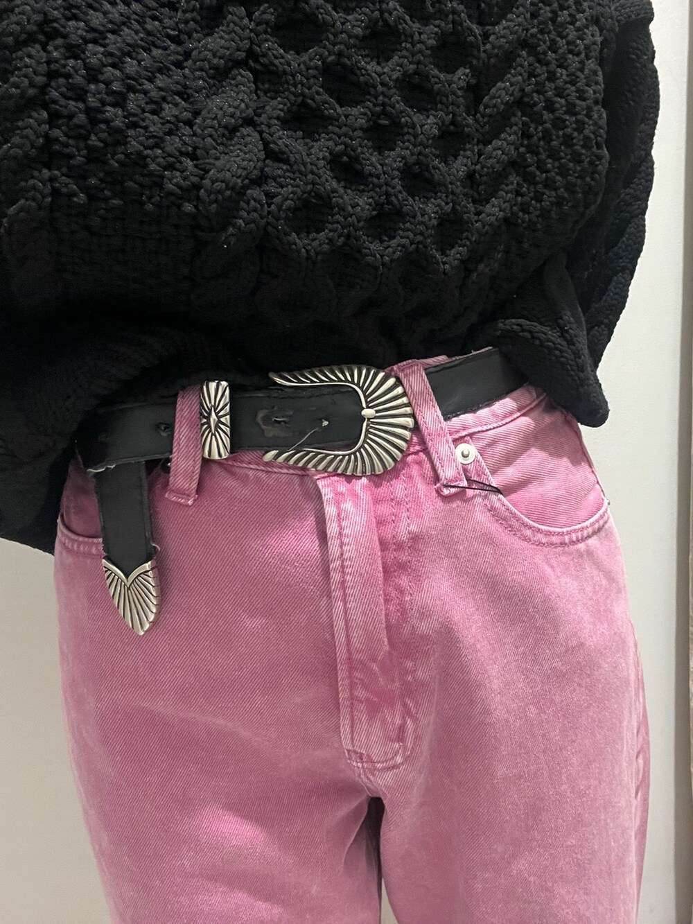 ピンク系のデニムパンツ、ブラック系のニット/セーター、ブルー系のショルダーバッグを着用したレディースの冬コーディネートの2枚目の写真