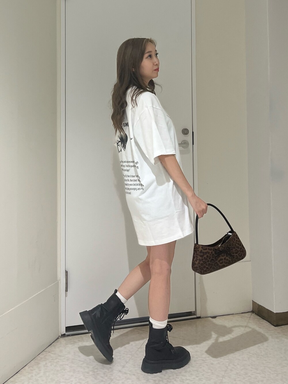 ブラック系のブーツ、ブラウン系のハンドバッグ、ホワイト系のTシャツ/カットソーを着用したレディースの夏コーディネートの4枚目の写真