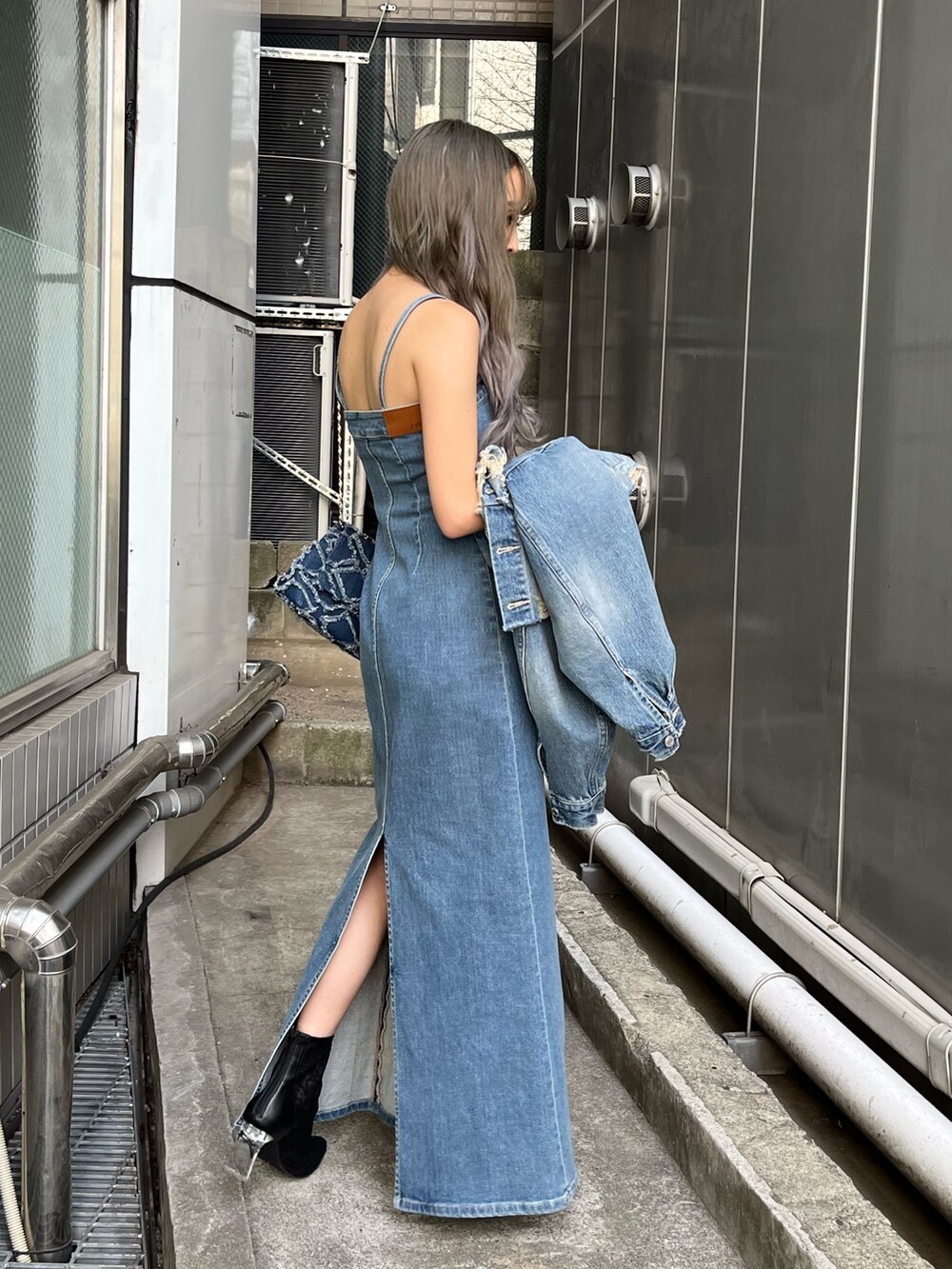 ブルー系のデニムジャケット、ブルー系のワンピース、ブルー系のショルダーバッグを着用したレディースの冬コーディネートの5枚目の写真