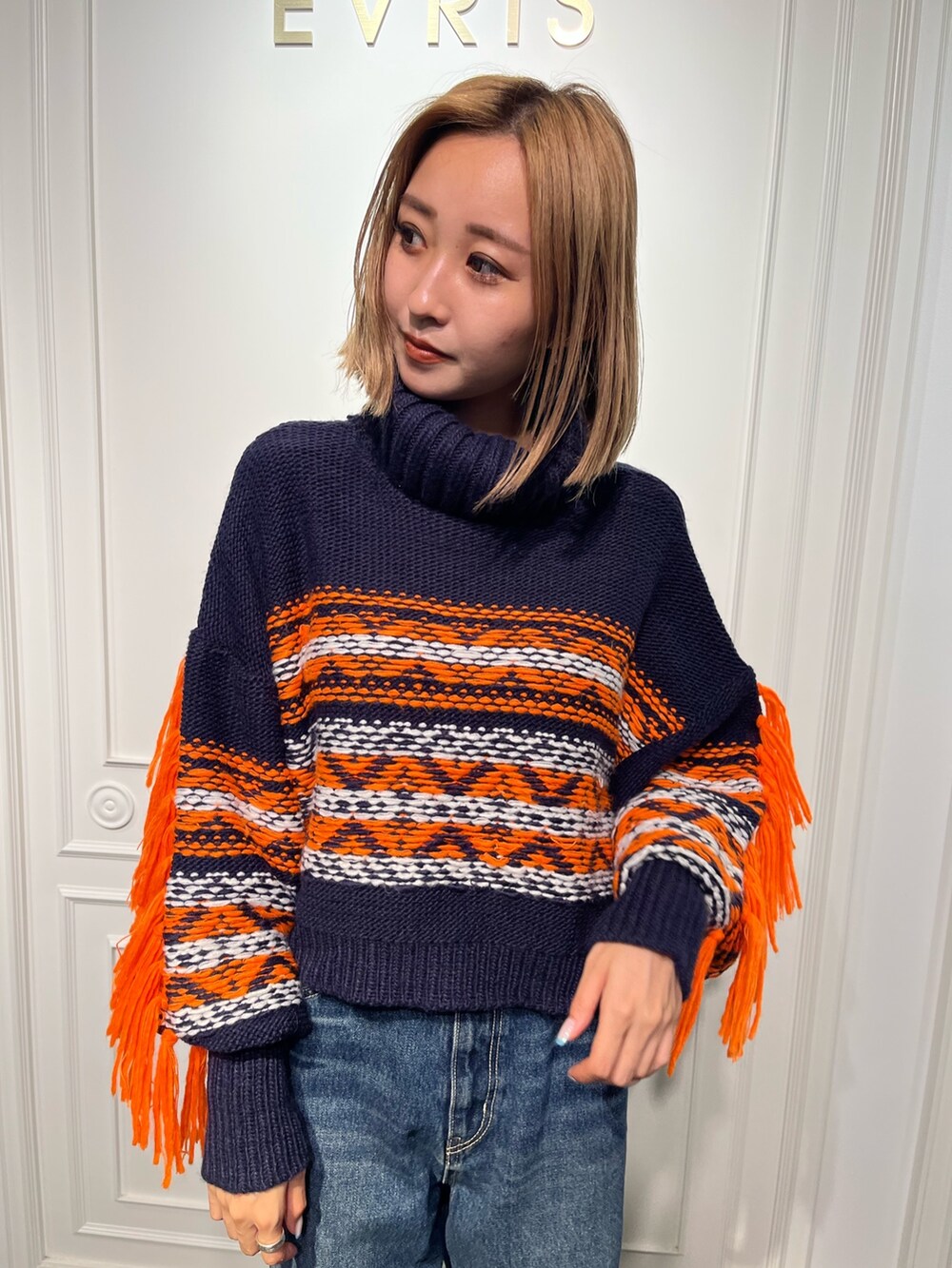 ブルー系のニット/セーター、ブラック系のブーツ、ブラック系のデニムパンツを着用したレディースの秋コーディネートの4枚目の写真