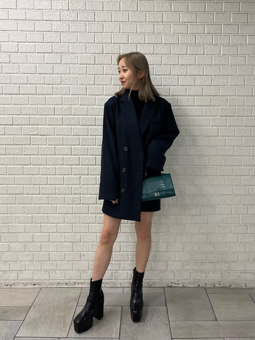 ブルー系のテーラードジャケット、ブラック系のワンピース、ブラック系のブーツを着用したレディースの秋コーディネートの4枚目の写真