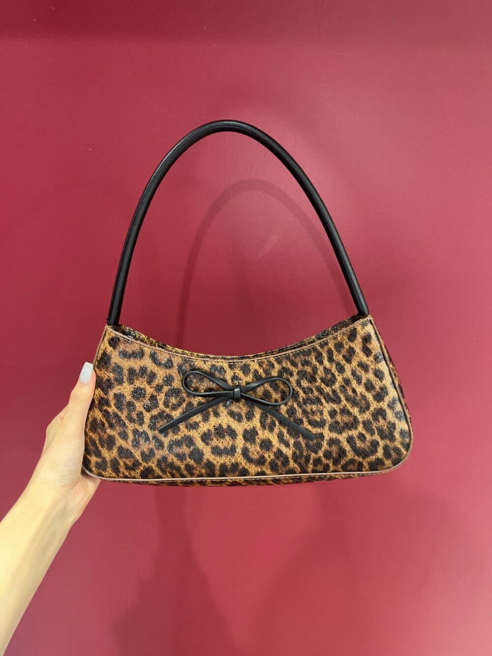 ブラウン系のハンドバッグ、ブラック系のサンダル、ホワイト系のシャツ/ブラウスを着用したレディースの夏コーディネートの6枚目の写真