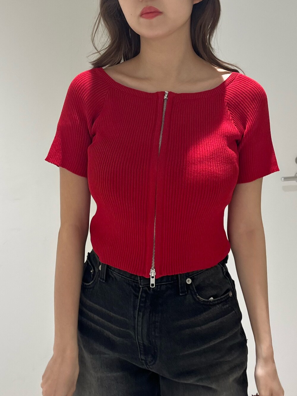 ブラック系のブーツ、ブラック系のデニムパンツ、ブラック系のハンドバッグを着用したレディースの春コーディネートの6枚目の写真