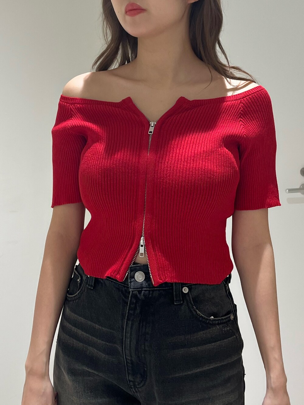 ブラック系のブーツ、ブラック系のデニムパンツ、ブラック系のハンドバッグを着用したレディースの春コーディネートの5枚目の写真