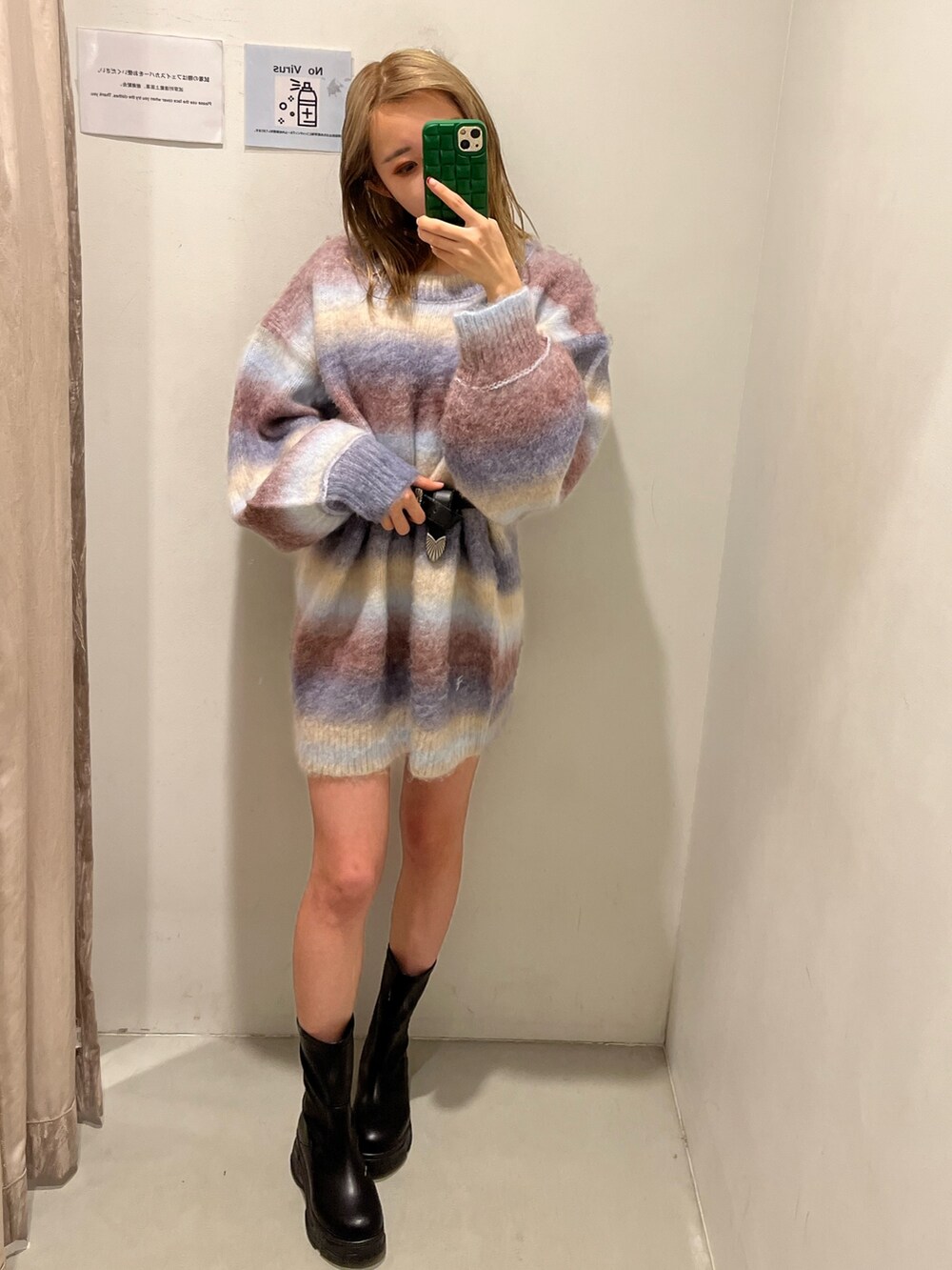 パープル系のニット/セーター、ブラック系のブーツ、ブラック系のベルトを着用したレディースの冬コーディネートの2枚目の写真