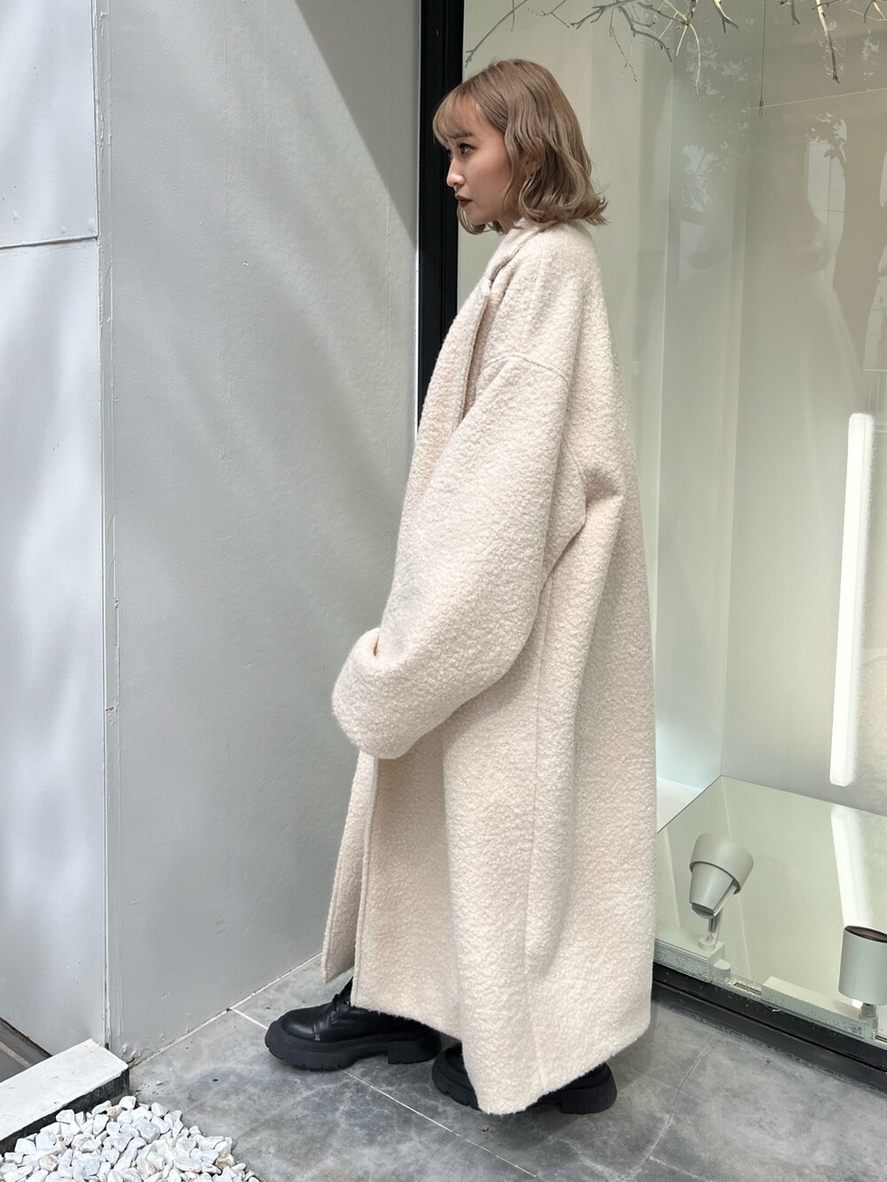 ブルー系のニット/セーター、シルバー系のショルダーバッグ、ホワイト系のブーツを着用したレディースの秋コーディネートの2枚目の写真