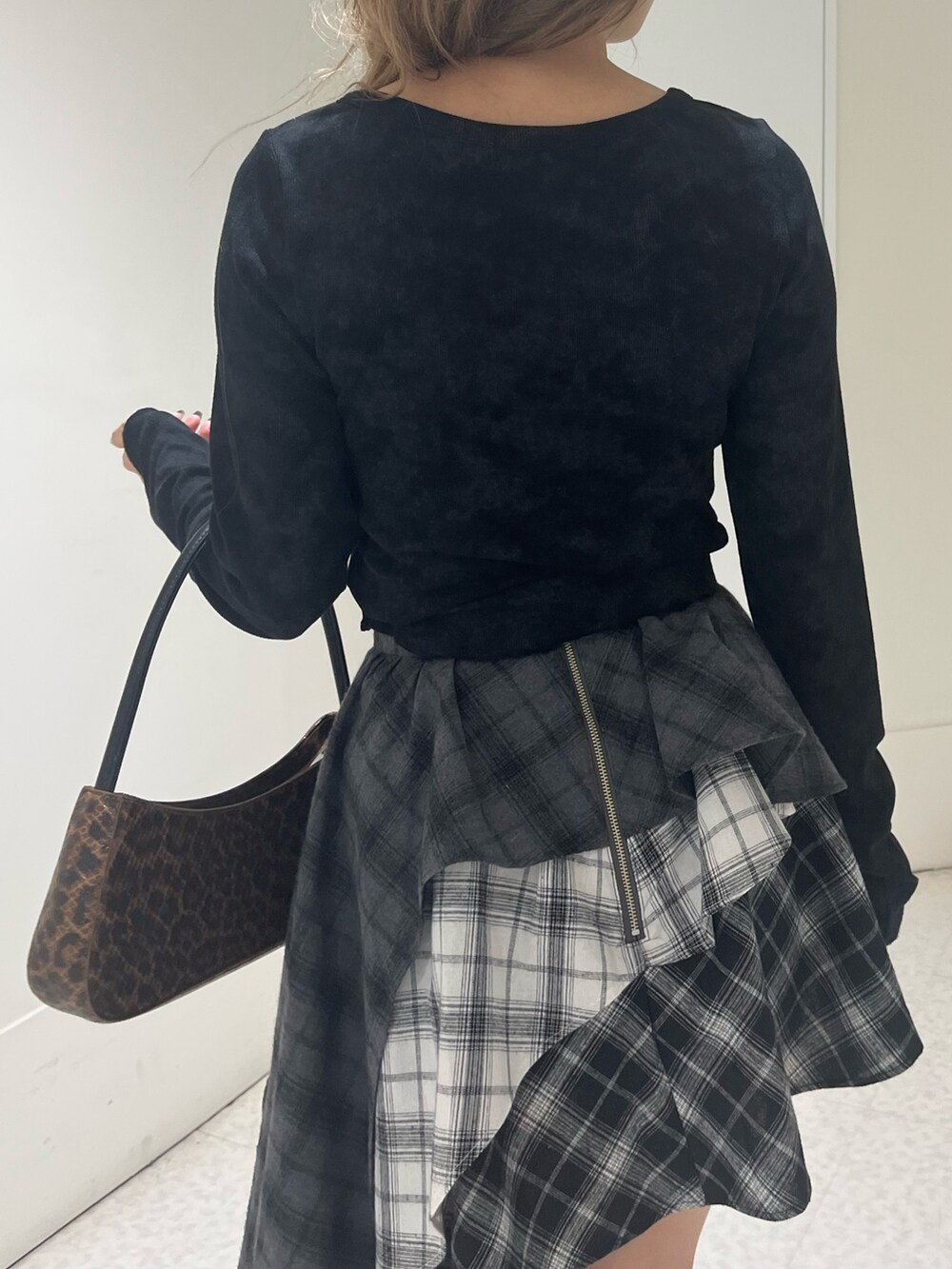 ブラウン系のハンドバッグ、ブラック系のブーツ、ブラック系のTシャツ/カットソーを着用したレディースの春コーディネートの5枚目の写真