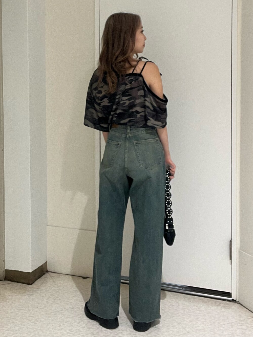ブルー系のデニムパンツ、その他のTシャツ/カットソー、ブラック系のブーツを着用したレディースの春コーディネートの2枚目の写真