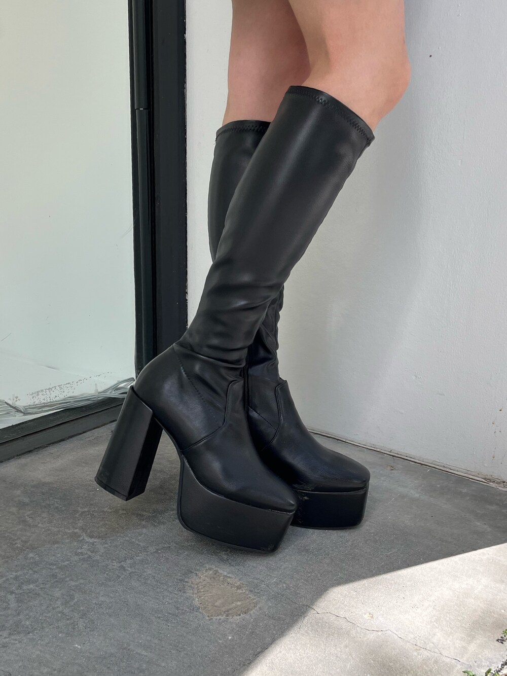 グレー系のスカート、グレー系のTシャツ/カットソー、ブラック系のムートンコートを着用したレディースの秋コーディネートの6枚目の写真