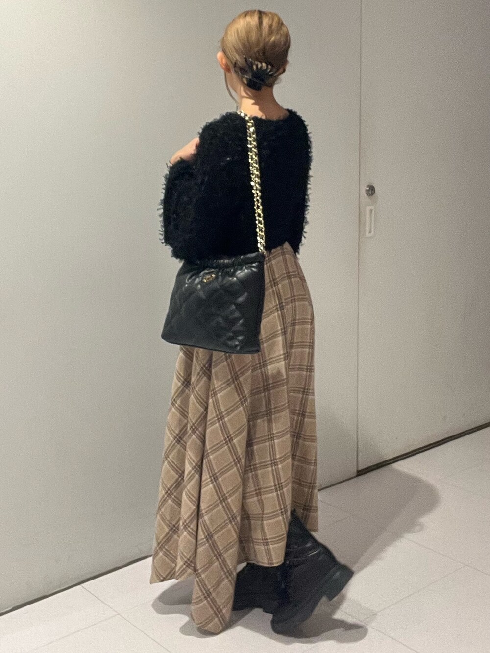 ブラック系のニット/セーター、ブラック系のワンピース、ブラック系のショルダーバッグを着用したレディースの秋コーディネートの3枚目の写真