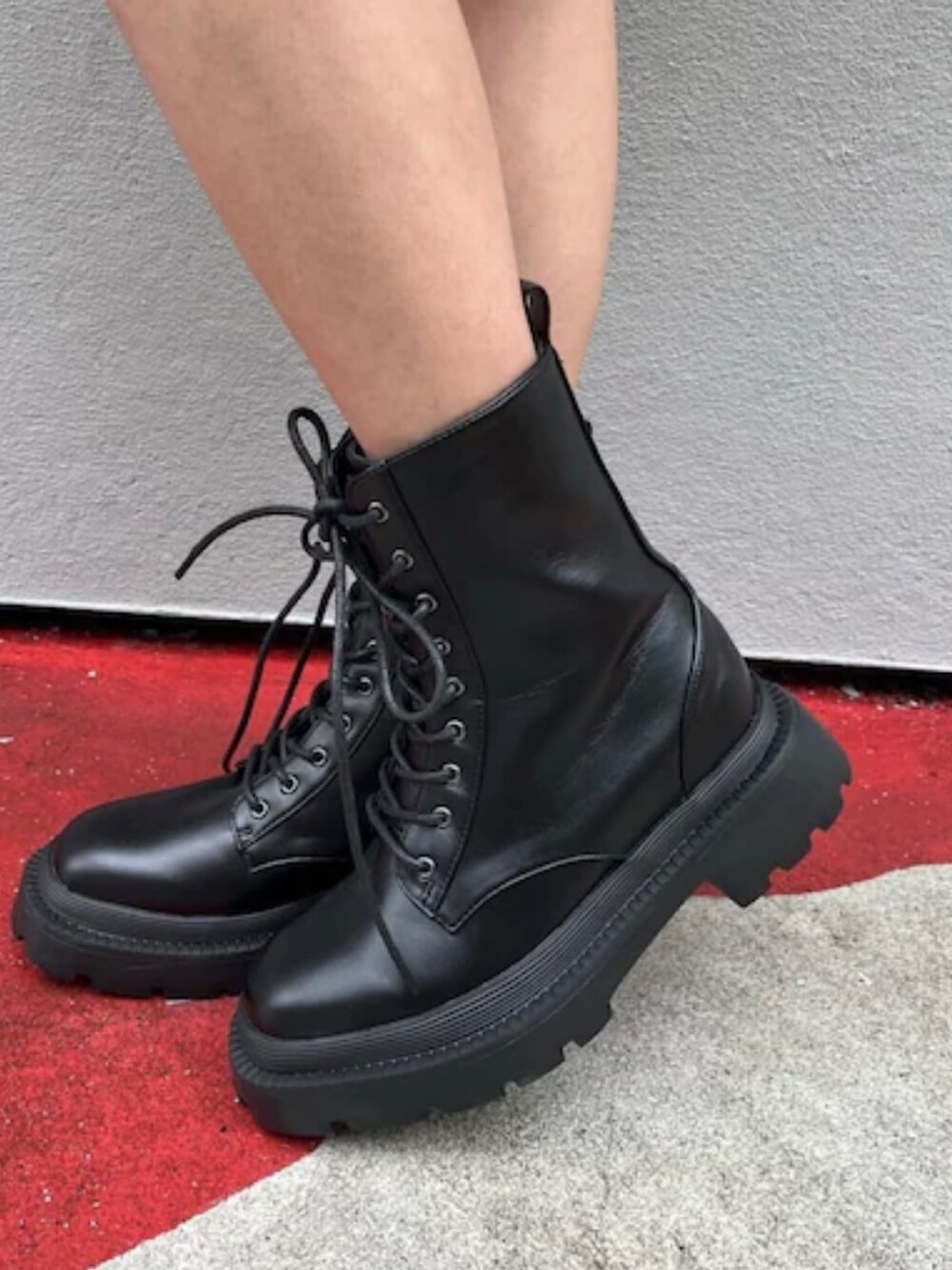 ホワイト系のカーゴパンツ、ブラック系のタンクトップ、ホワイト系のブーツを着用したレディースの夏コーディネートの9枚目の写真