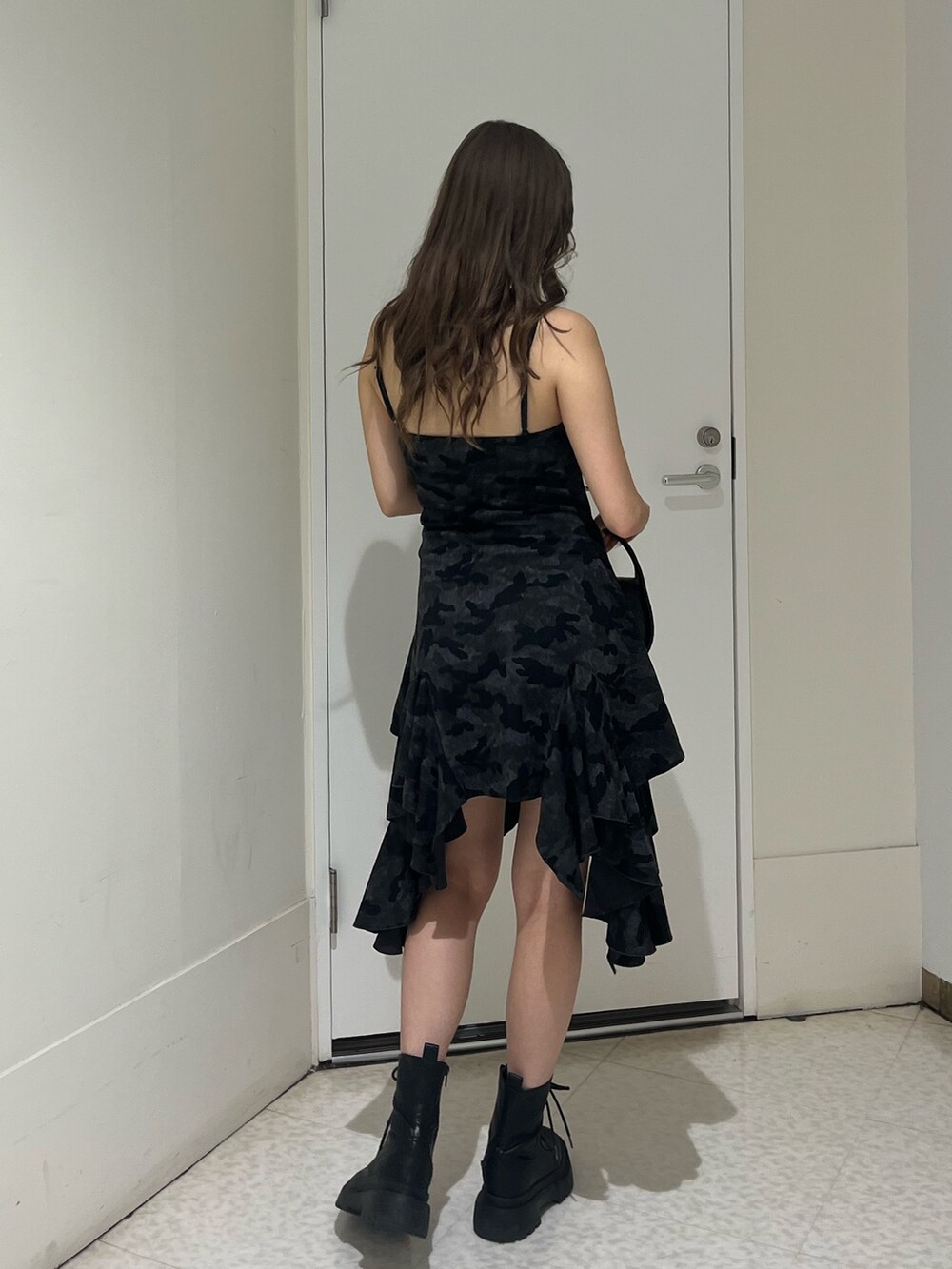 ブラック系のワンピース、ブラック系のハンドバッグ、ブラック系のブーツを着用したレディースの夏コーディネートの3枚目の写真