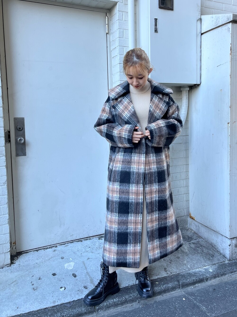 ホワイト系のワンピース、グリーン系のその他アウター、ブラック系のブーツを着用したレディースの冬コーディネートの2枚目の写真