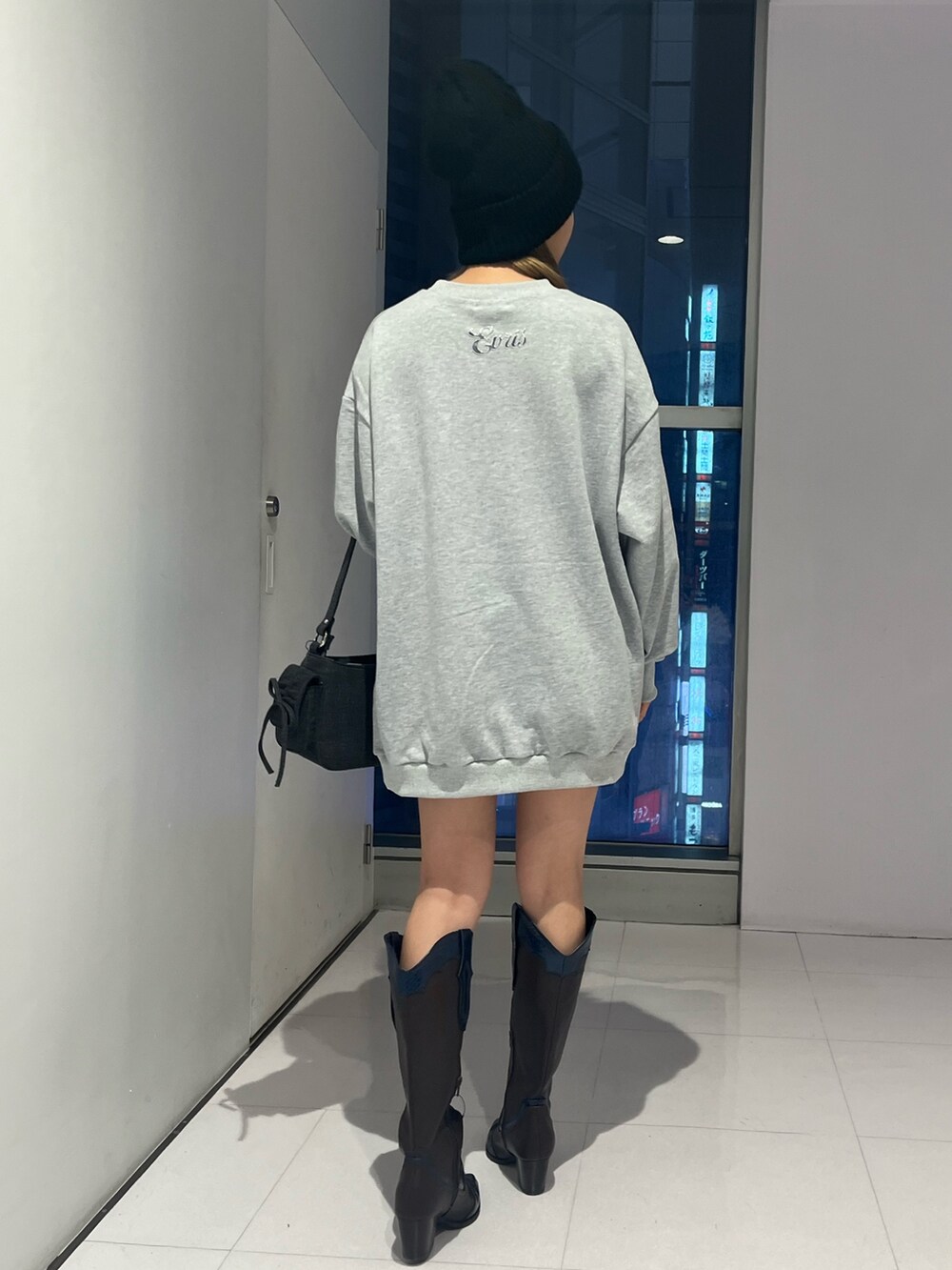 ブラック系のハンドバッグ、グレー系のTシャツ/カットソー、ブラウン系のブーツを着用したレディースの秋コーディネートの3枚目の写真