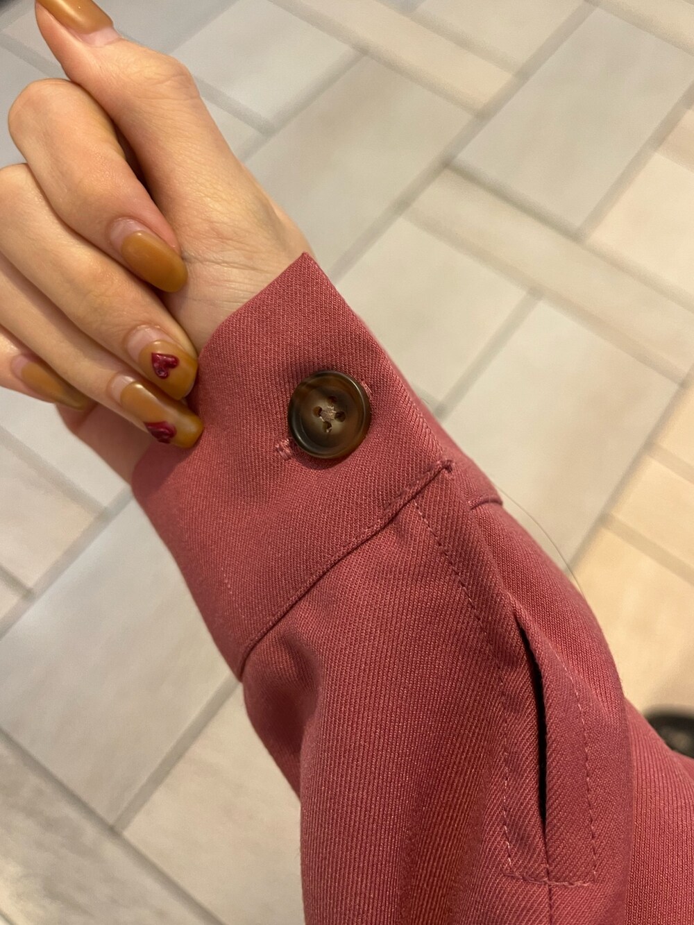 ブラック系のブーツ、ブラック系のショルダーバッグ、ピンク系のワンピースを着用したレディースの冬コーディネートの4枚目の写真