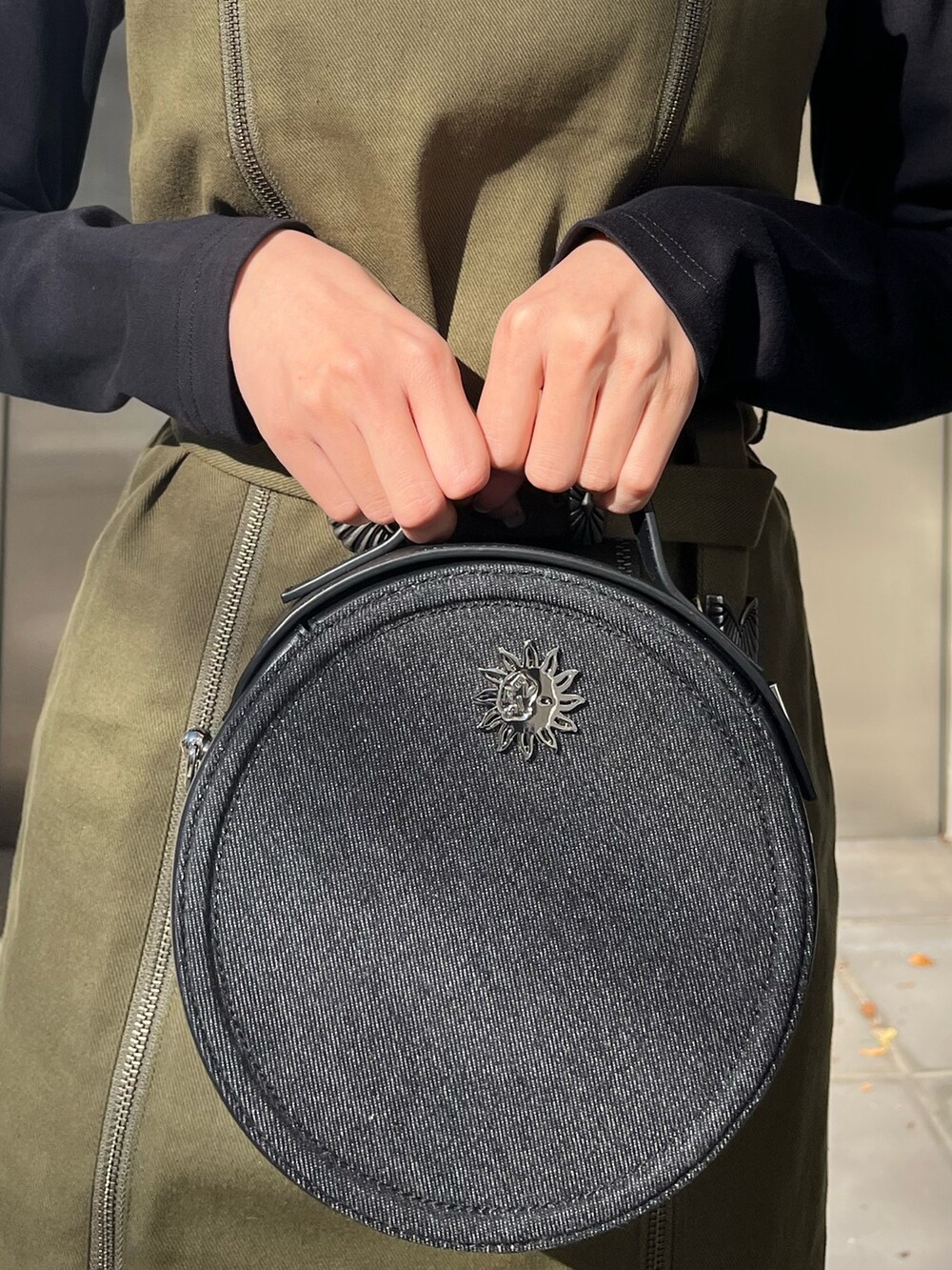 ブラック系のワンピース、ブラック系のショルダーバッグ、ブラック系のブーツを着用したレディースの冬コーディネートの4枚目の写真