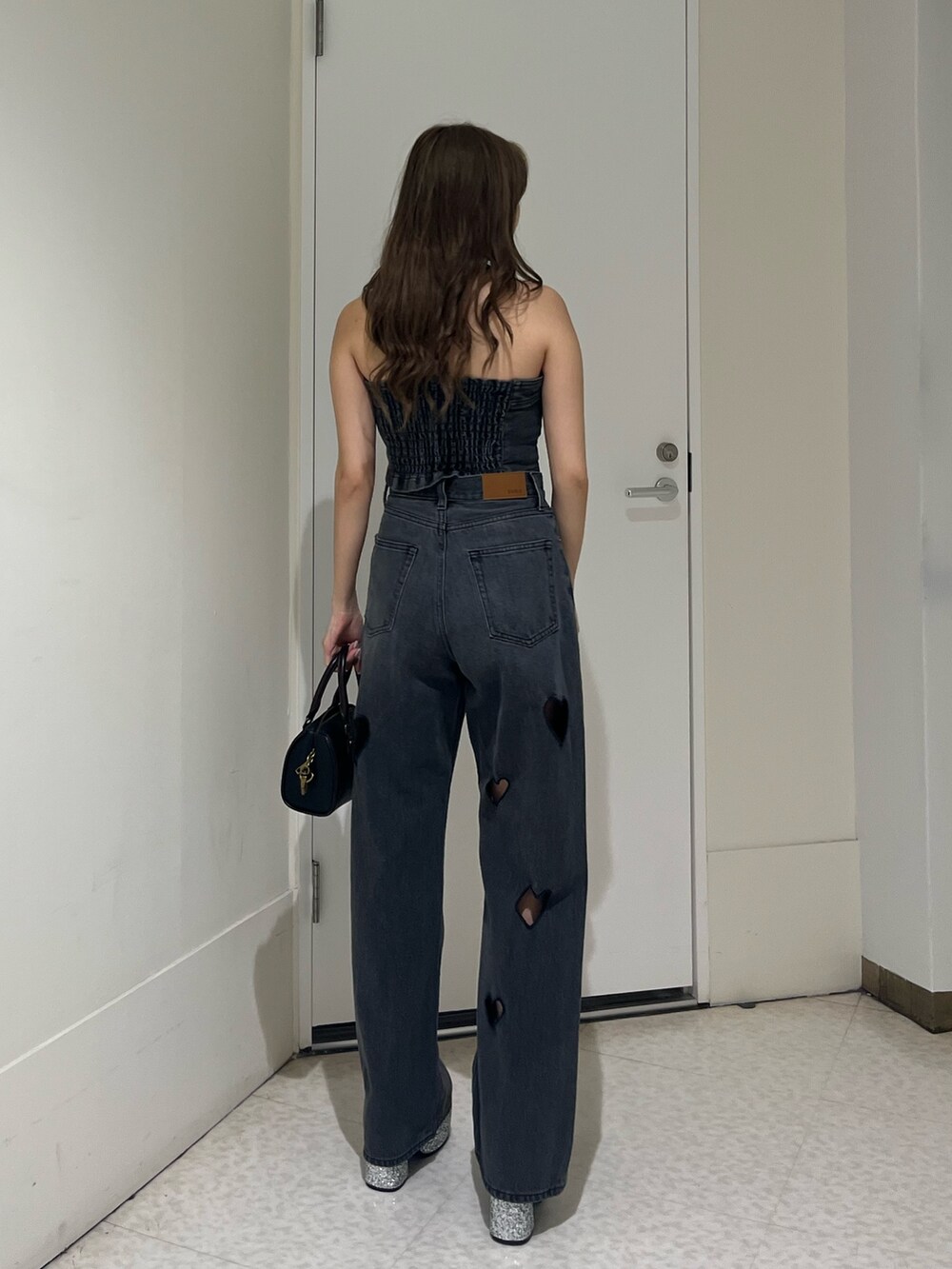 ブラック系のキャミソール、ブラック系のデニムパンツ、シルバー系のサンダルを着用したレディースの夏コーディネートの3枚目の写真