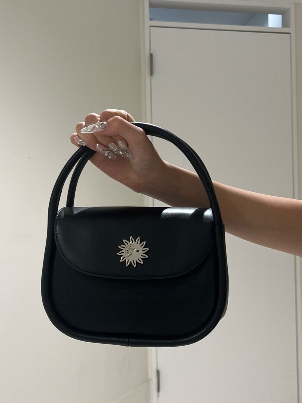 ブラック系のハンドバッグ、ブラック系のサンダル、ピンク系のタンクトップを着用したレディースの夏コーディネートの6枚目の写真