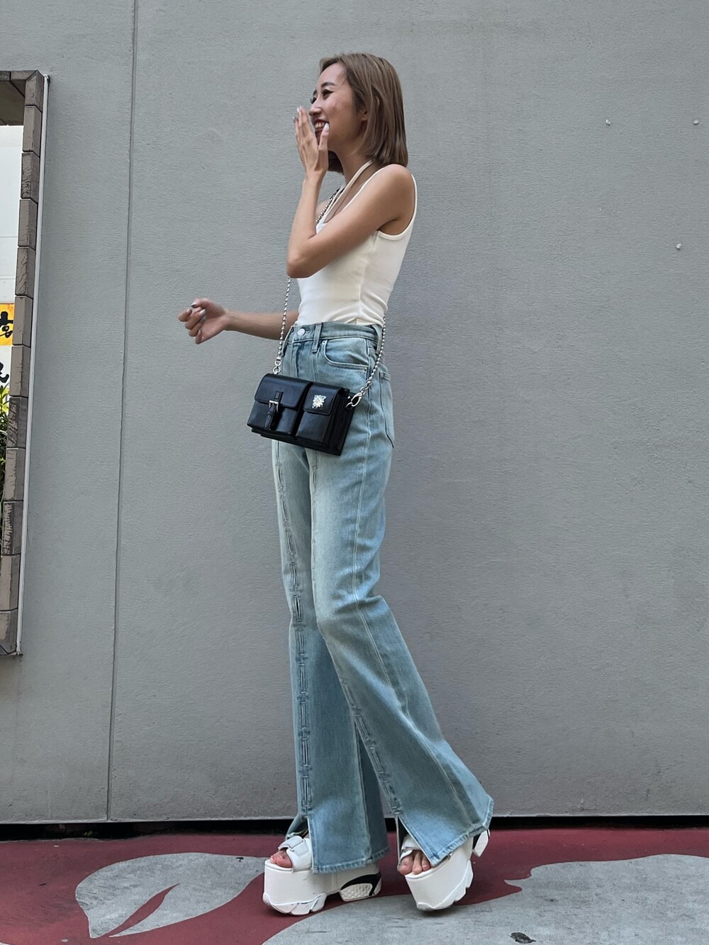 ホワイト系のサンダル、ブラック系のショルダーバッグ、ホワイト系のキャミソールを着用したレディースの夏コーディネートの3枚目の写真