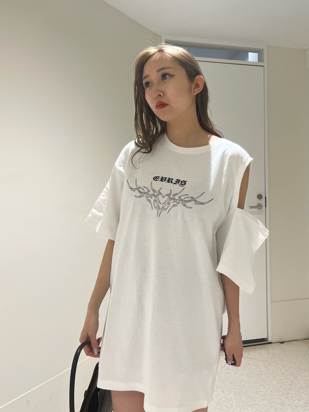 ブラック系のブーツ、ブラウン系のハンドバッグ、ホワイト系のTシャツ/カットソーを着用したレディースの夏コーディネートの5枚目の写真