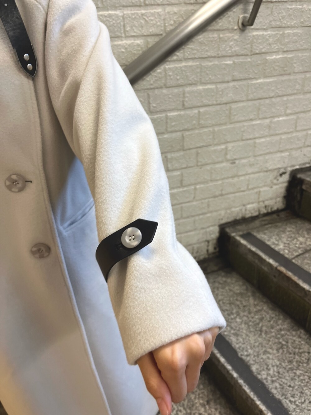 ホワイト系のその他アウター、ブラック系のその他パンツ、ブラック系のショルダーバッグを着用したレディースの冬コーディネートの6枚目の写真