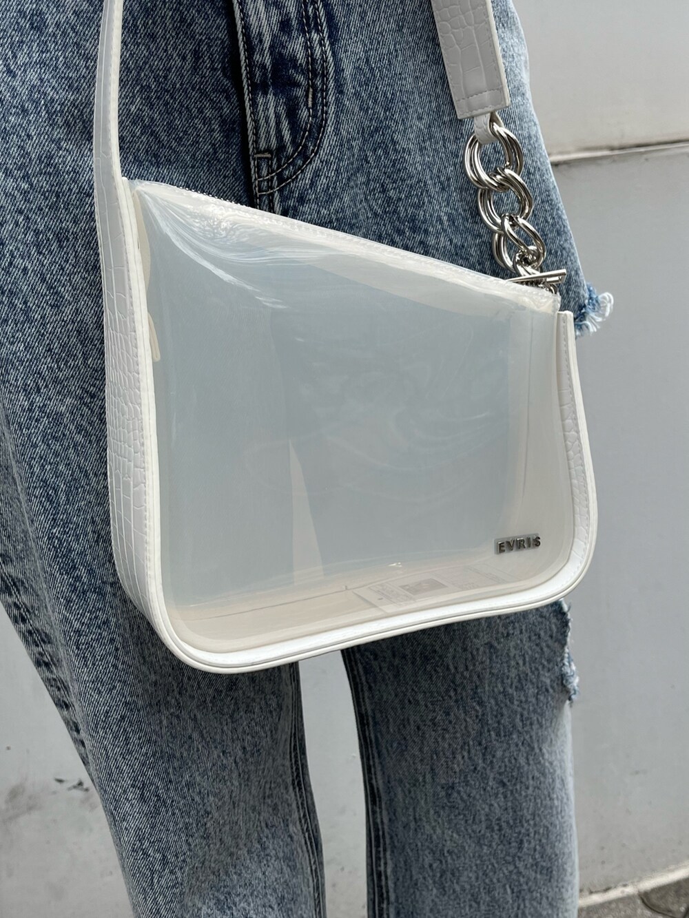 ブルー系のデニムパンツ、オレンジ系のタンクトップ、ブラック系のサンダルを着用したレディースの春コーディネートの7枚目の写真