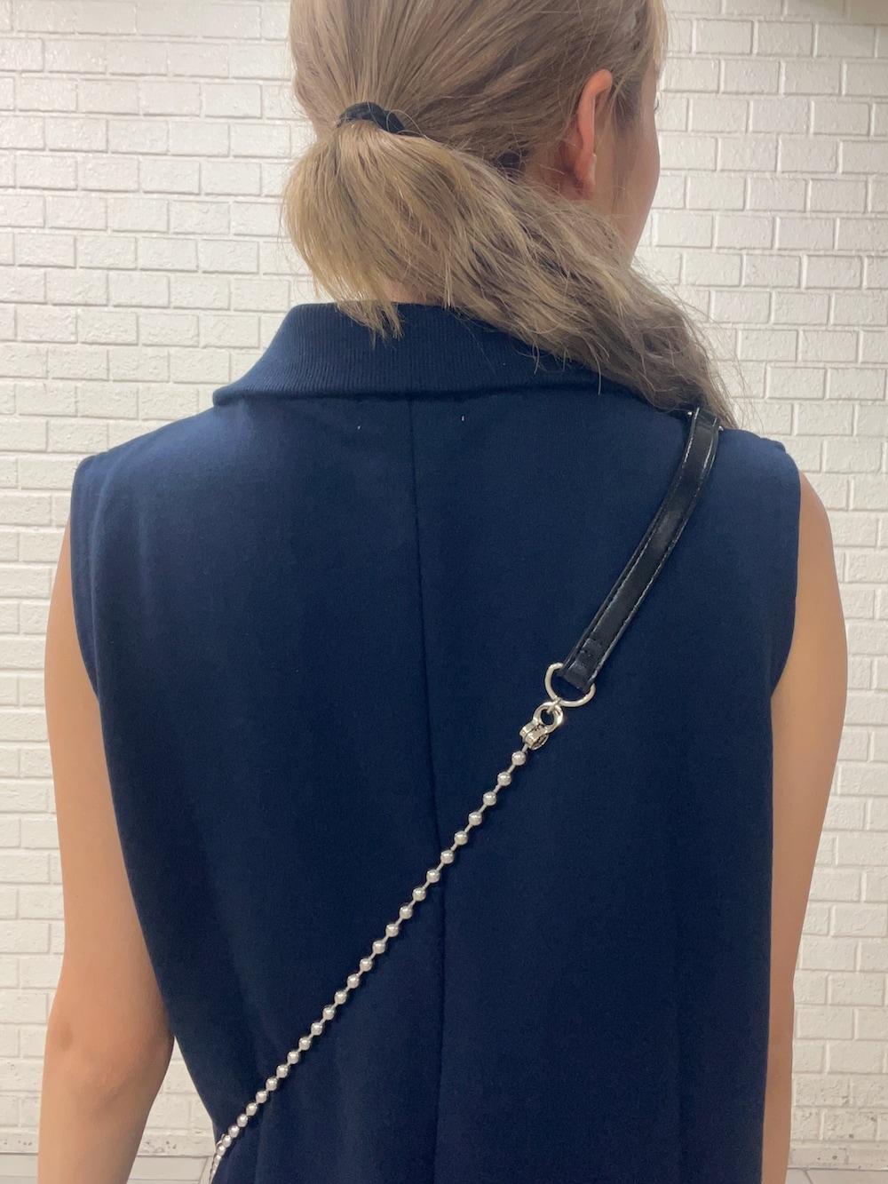 ブルー系のショルダーバッグ、ブルー系のワンピース、ホワイト系のブーツを着用したレディースの秋コーディネートの4枚目の写真