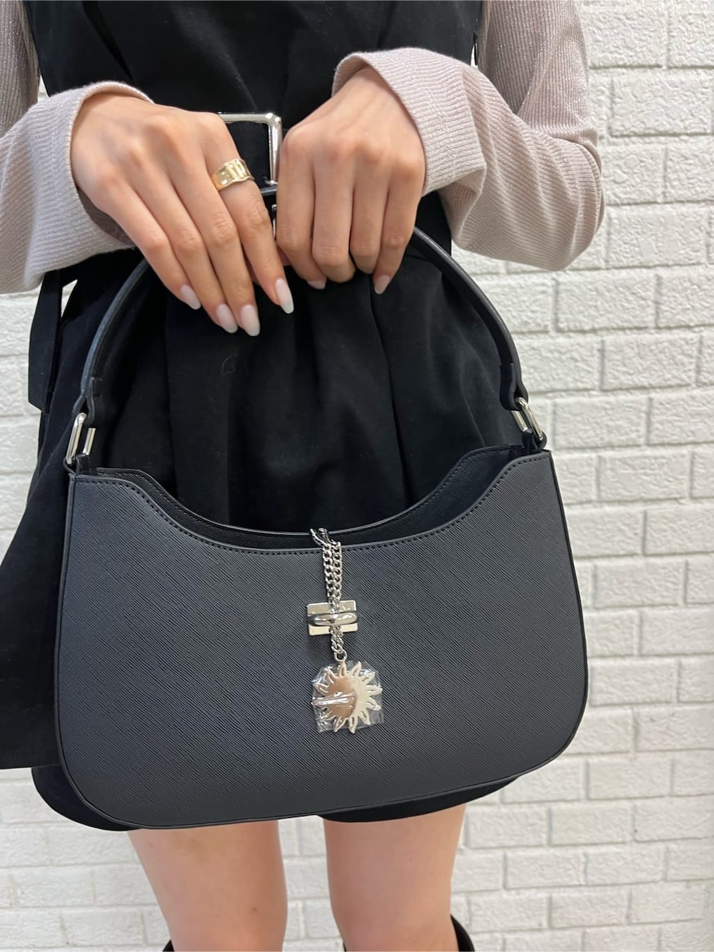 ブラック系のブーツ、ブラック系のハンドバッグ、ホワイト系のTシャツ/カットソーを着用したレディースの秋コーディネートの5枚目の写真