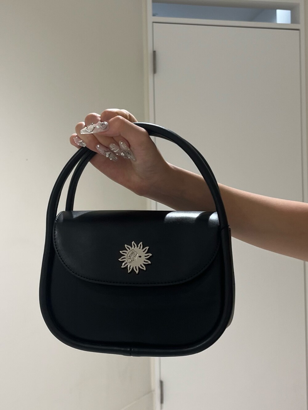 ベージュ系のスカート、ブラック系のハンドバッグ、ブラック系のサンダルを着用したレディースの夏コーディネートの6枚目の写真