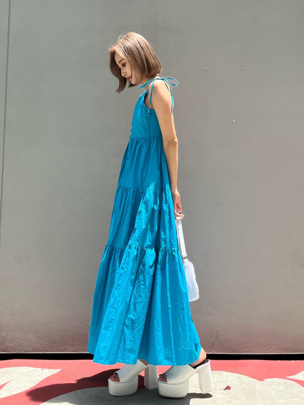 ホワイト系のサンダル、ブラック系のワンピースを着用したレディースの夏コーディネートの4枚目の写真