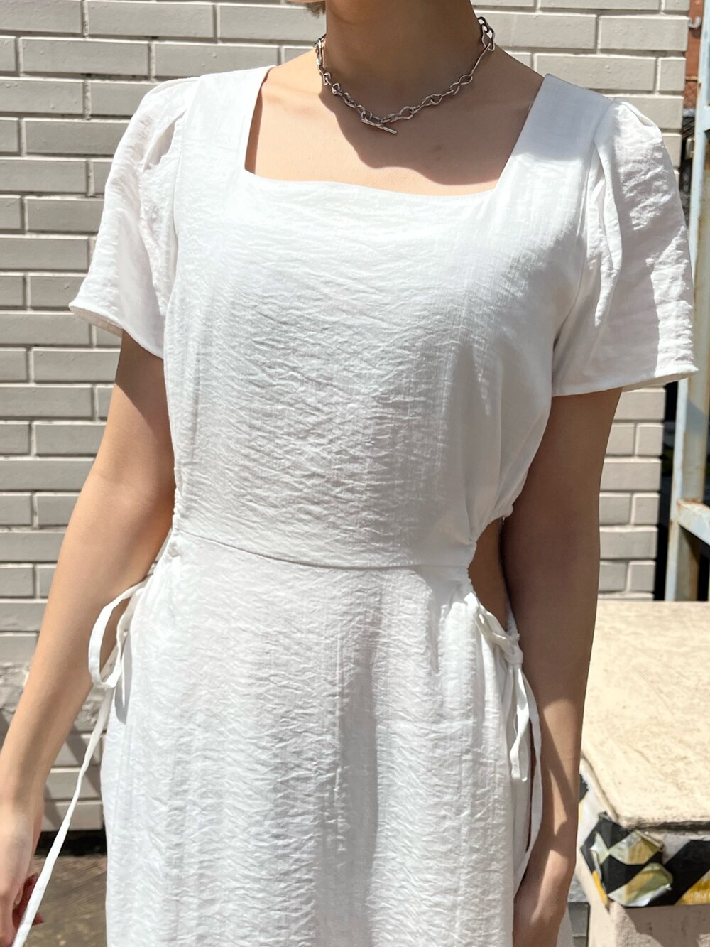 ホワイト系のワンピース、ベージュ系のサンダル、ブルー系のショルダーバッグを着用したレディースの春コーディネートの4枚目の写真