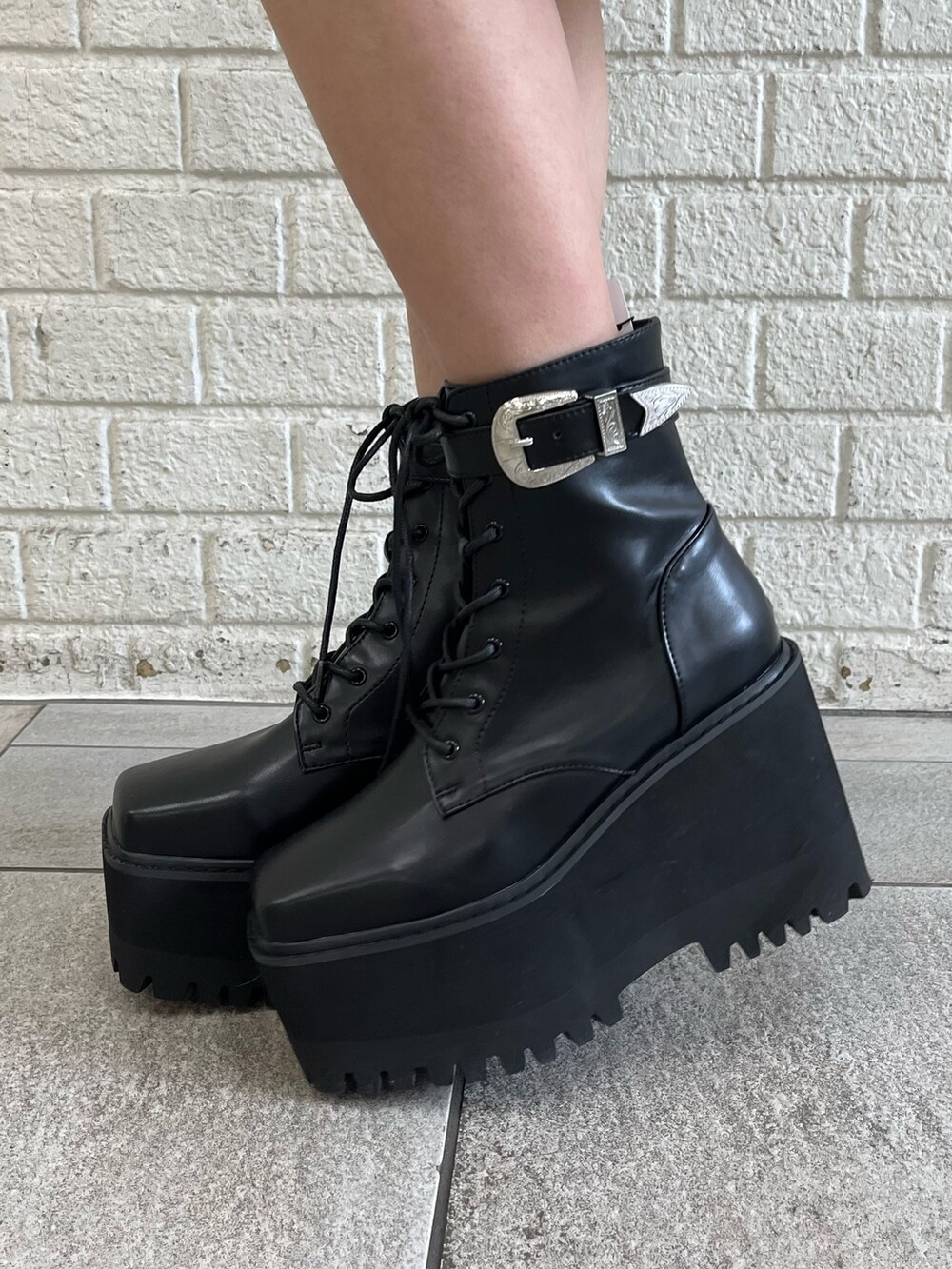 オレンジ系のテーラードジャケット、オレンジ系のキャミソール、ブラック系のブーツを着用したレディースの冬コーディネートの7枚目の写真