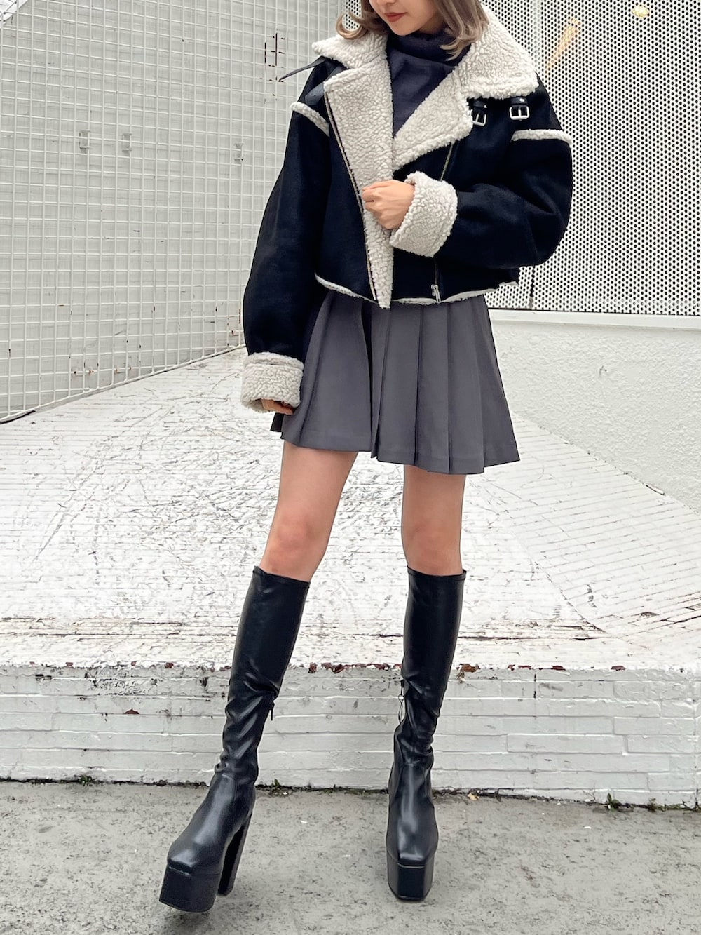 グレー系のスカート、グレー系のTシャツ/カットソー、ホワイト系のブーツを着用したレディースの秋コーディネートの6枚目の写真