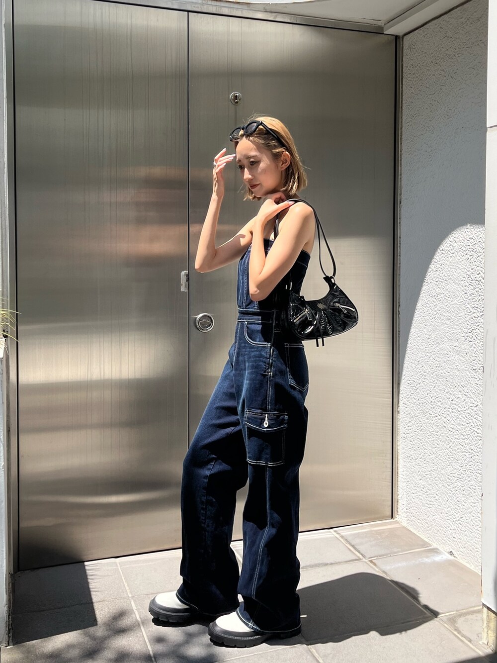 ホワイト系のブーツ、ブルー系のつなぎ/オールインワン、ブラック系のサングラスを着用したレディースの夏コーディネートの2枚目の写真