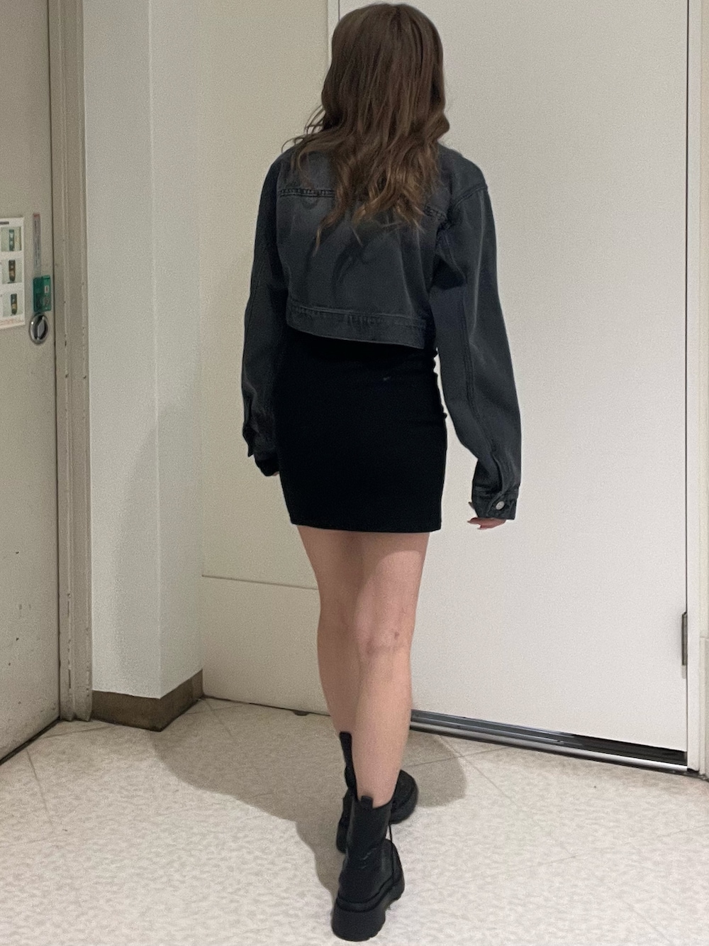 ブルー系のデニムジャケット、ブラック系のワンピース、ブラック系のブーツを着用したレディースの春コーディネートの3枚目の写真