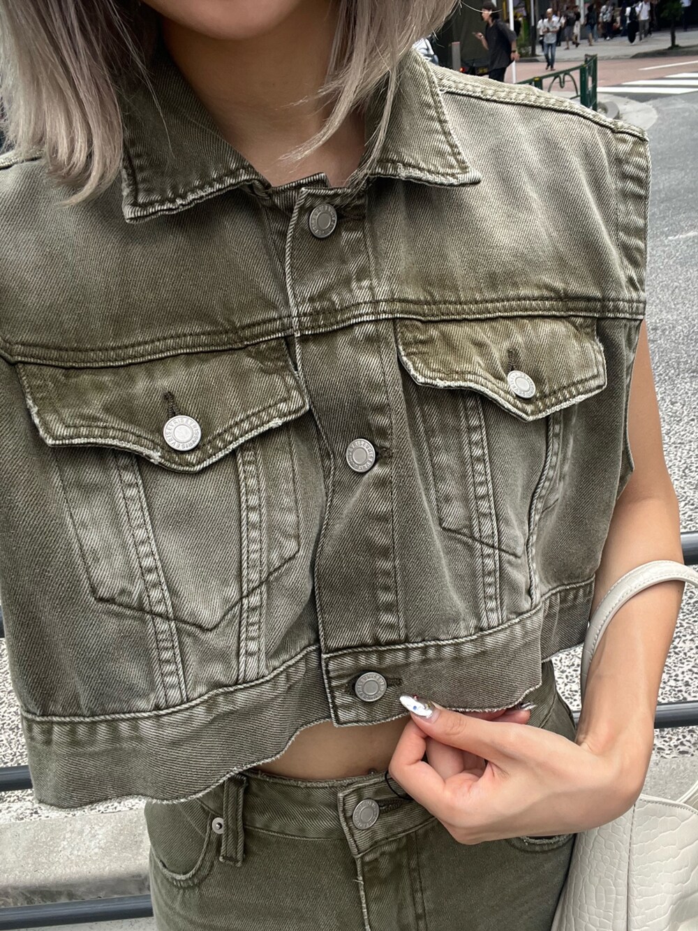 グリーン系のデニムジャケット、グリーン系のデニムスカート、ブラック系のハンドバッグを着用したレディースの秋コーディネートの6枚目の写真