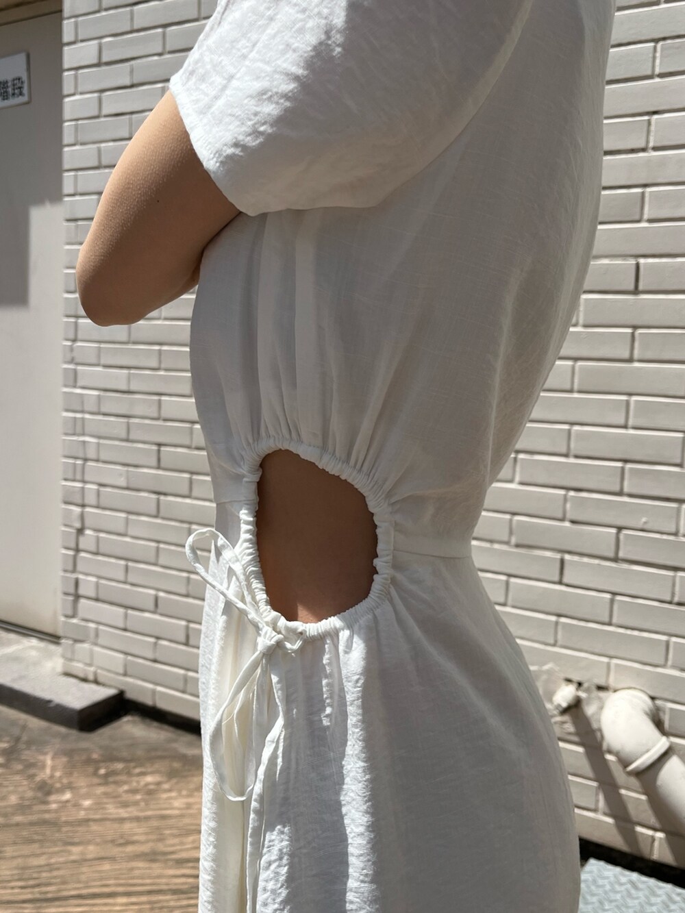 ホワイト系のワンピース、ベージュ系のサンダル、ブルー系のショルダーバッグを着用したレディースの春コーディネートの5枚目の写真