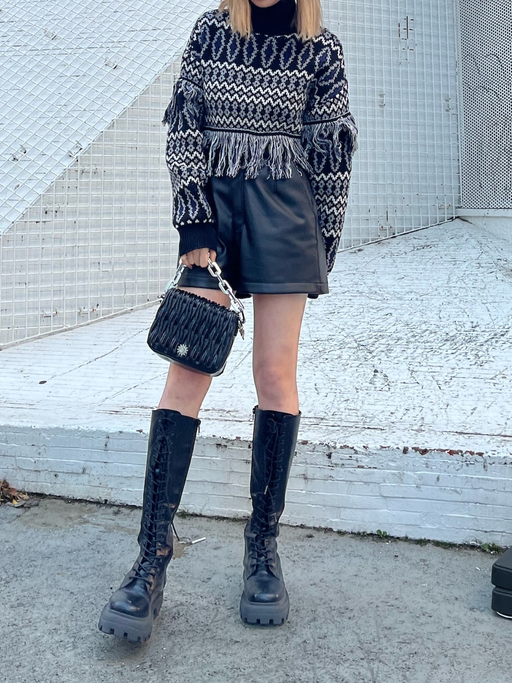 ブラック系のブーツ、シルバー系のショルダーバッグ、グリーン系のムートンコートを着用したレディースの冬コーディネートの6枚目の写真