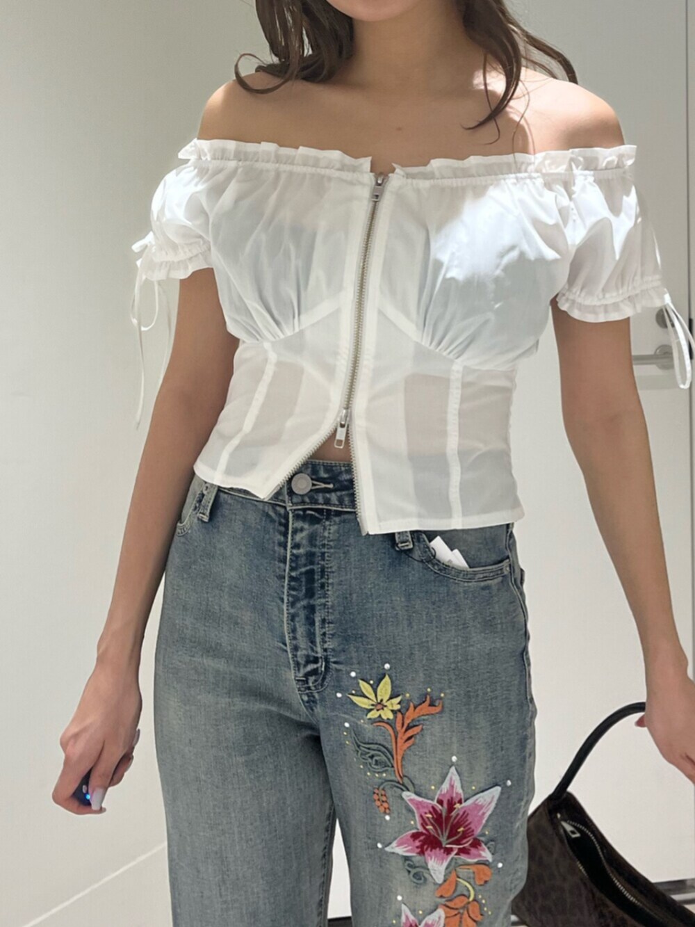 ブラウン系のハンドバッグ、ブラック系のサンダル、ホワイト系のシャツ/ブラウスを着用したレディースの夏コーディネートの5枚目の写真