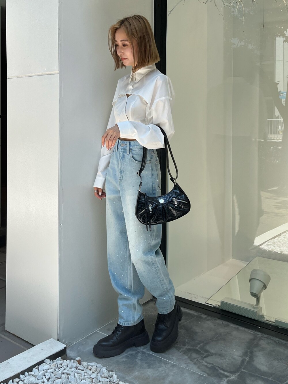 ホワイト系のシャツ/ブラウス、ブルー系のデニムパンツ、ブラック系のショルダーバッグを着用したレディースの秋コーディネートの2枚目の写真