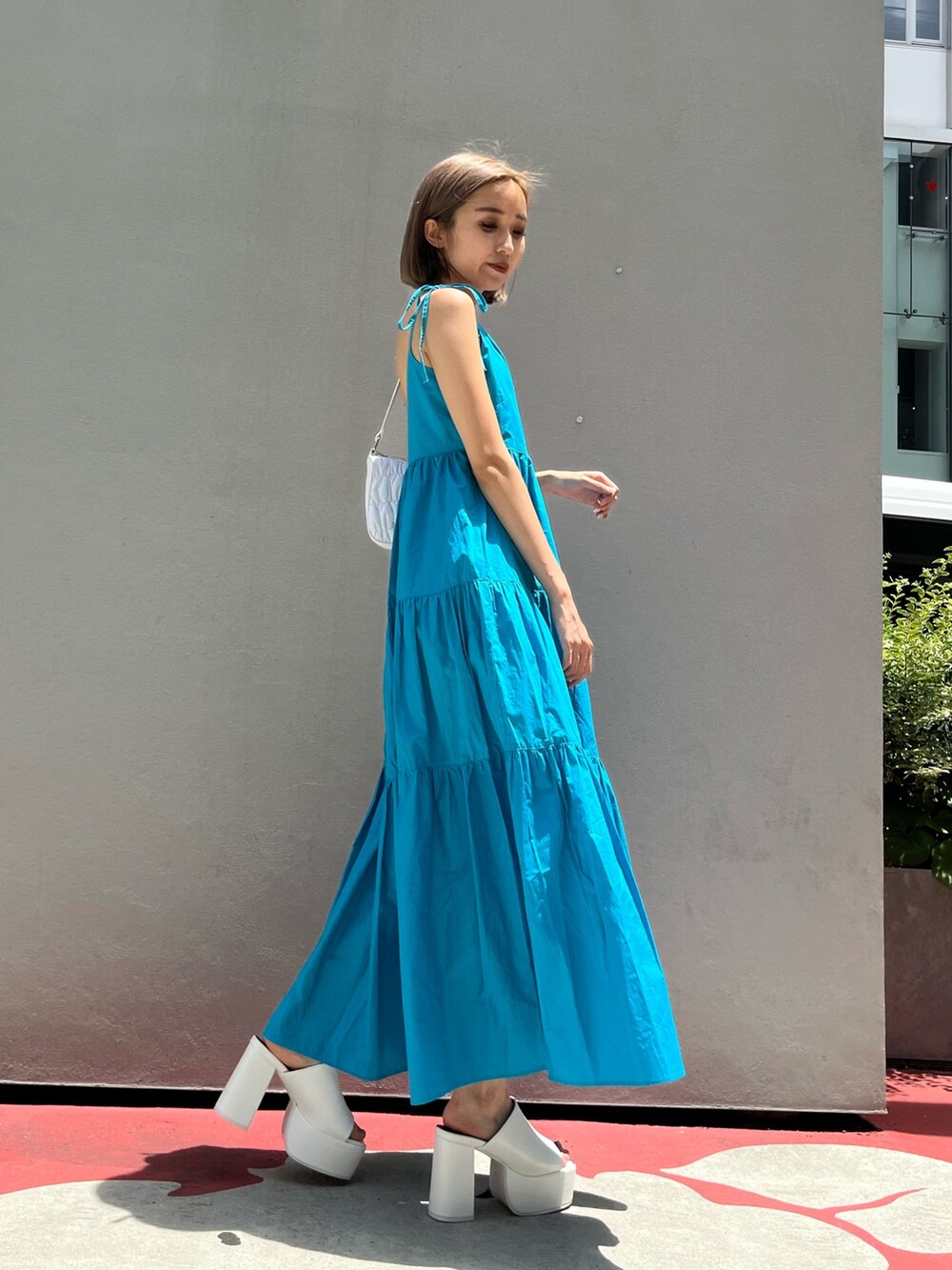 ホワイト系のサンダル、ブラック系のワンピースを着用したレディースの夏コーディネートの8枚目の写真