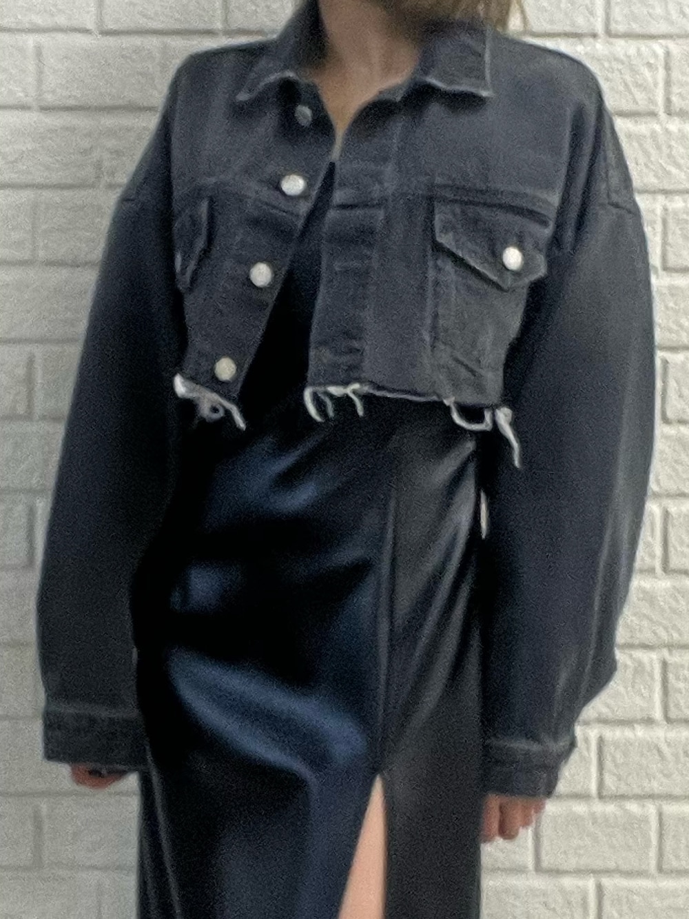 ブラック系のワンピース、ブルー系のデニムジャケット、ホワイト系のブーツを着用したレディースの冬コーディネートの6枚目の写真