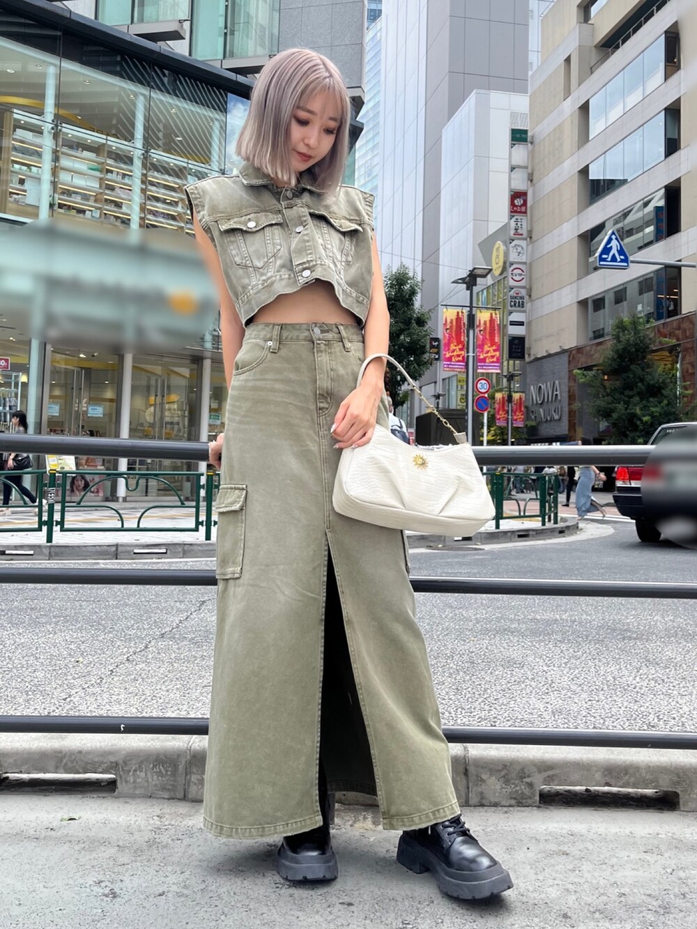 グリーン系のデニムジャケット、グリーン系のデニムスカート、ブラック系のハンドバッグを着用したレディースの秋コーディネートの4枚目の写真