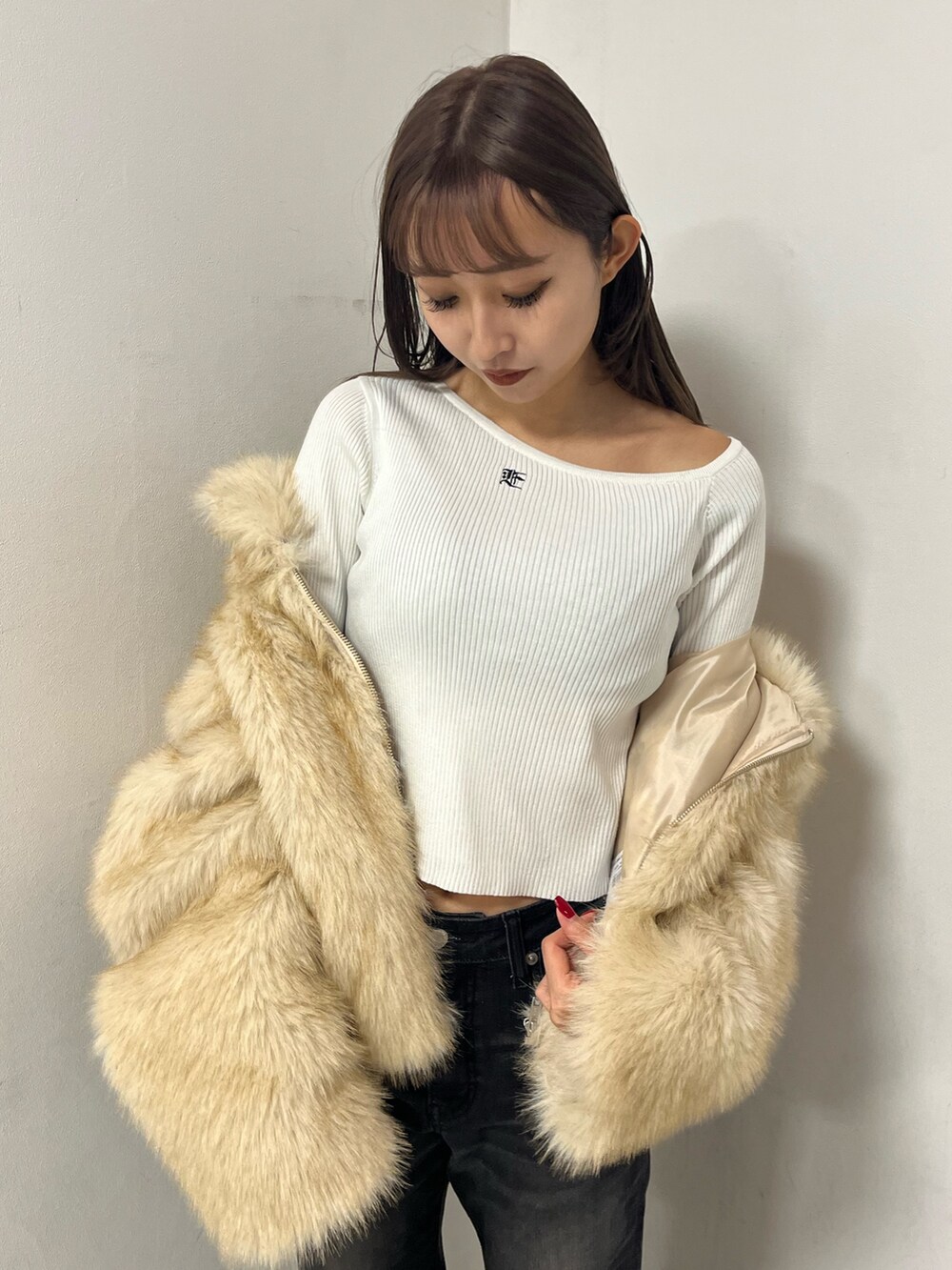 ベージュ系のブルゾン、ホワイト系のニット/セーター、ブラック系のデニムパンツを着用したレディースの冬コーディネートの3枚目の写真