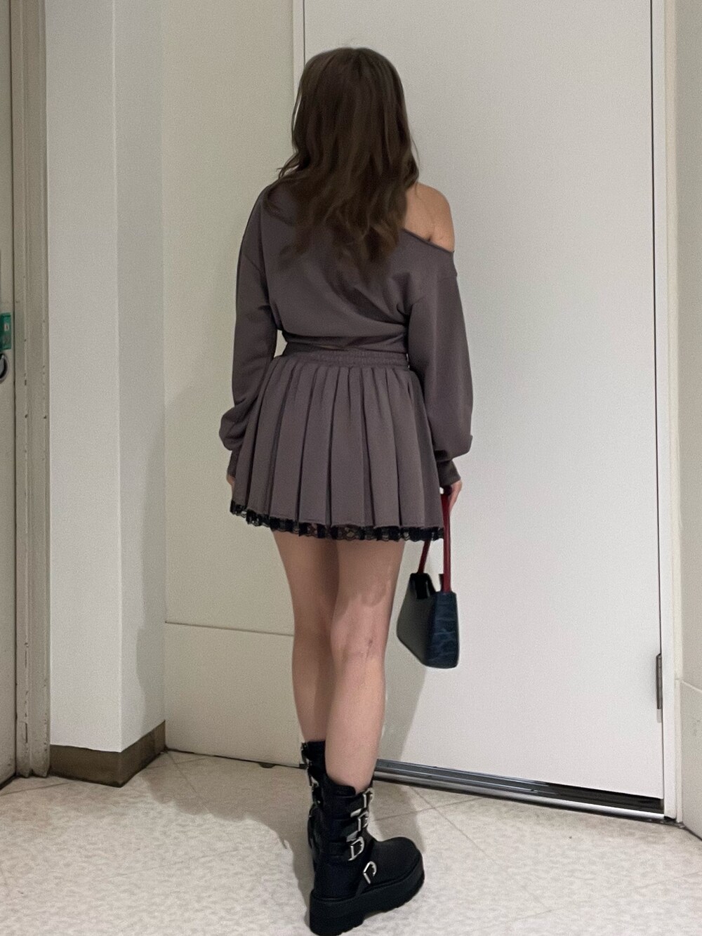 ブラック系のスウェット、ブラック系のスカート、ブラウン系のハンドバッグを着用したレディースの春コーディネートの3枚目の写真