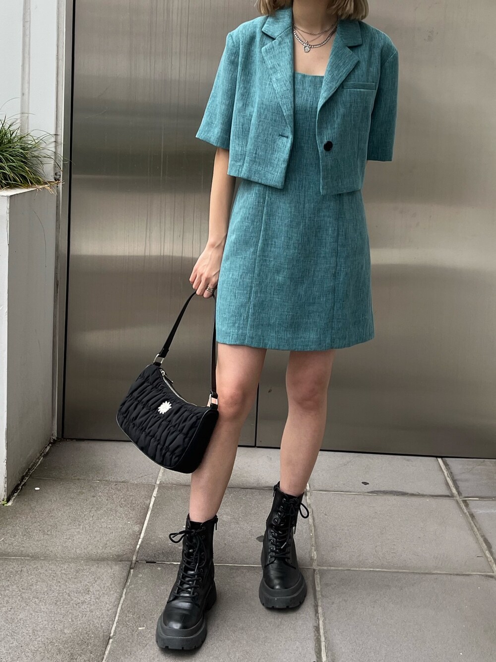 ホワイト系のブーツ、ブルー系のワンピース、シルバー系のネックレスを着用したレディースの春コーディネートの6枚目の写真