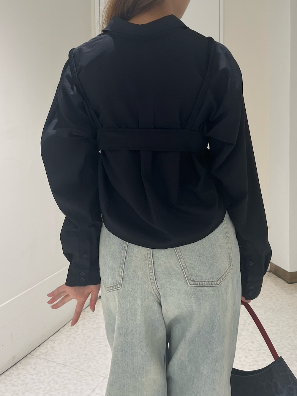 ブラック系のシャツ/ブラウス、ブルー系のデニムパンツ、ブラウン系のハンドバッグを着用したレディースの春コーディネートの5枚目の写真