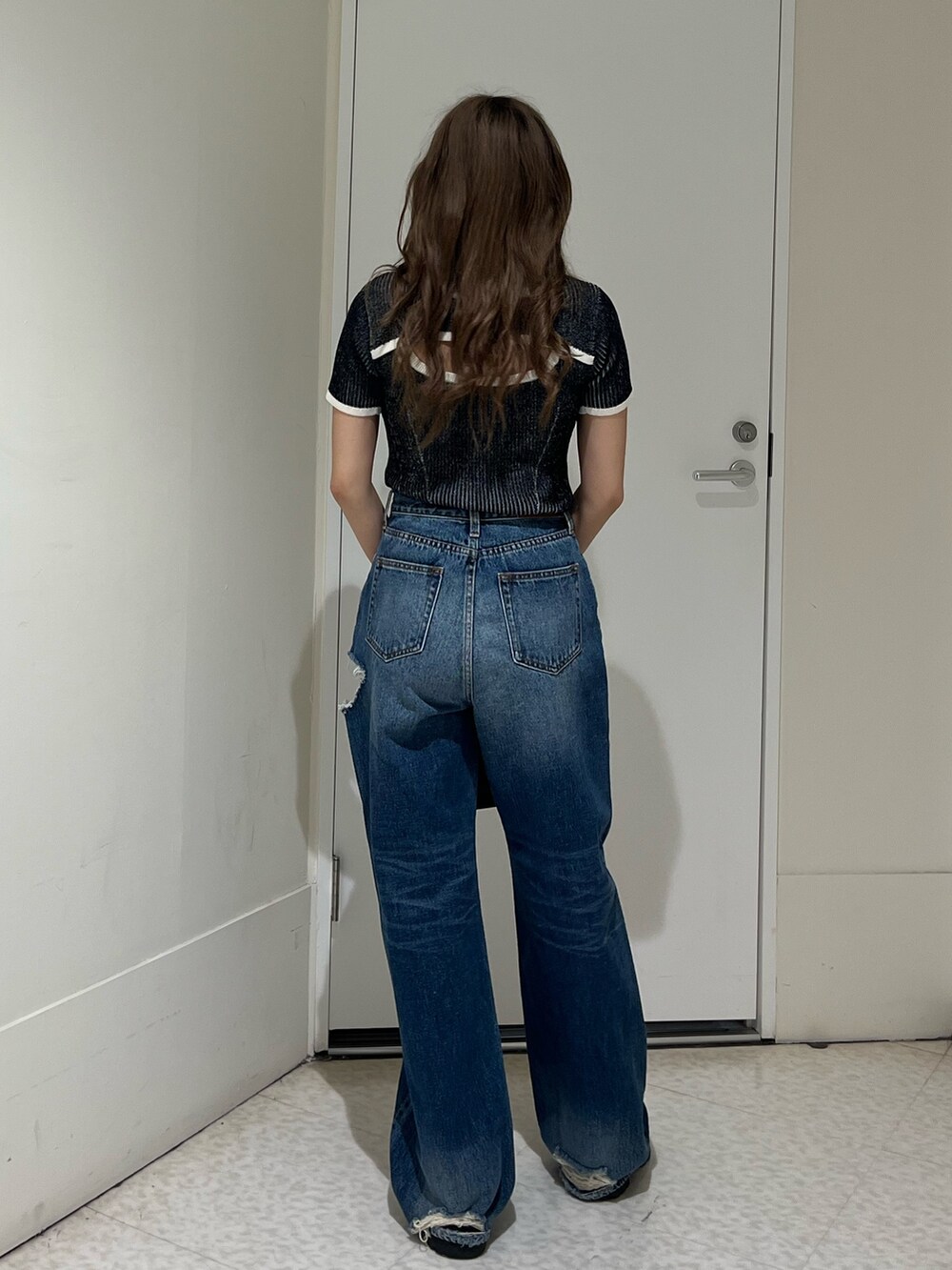 ブラック系のニット/セーター、ブルー系のデニムパンツ、その他のショルダーバッグを着用したレディースの春コーディネートの3枚目の写真