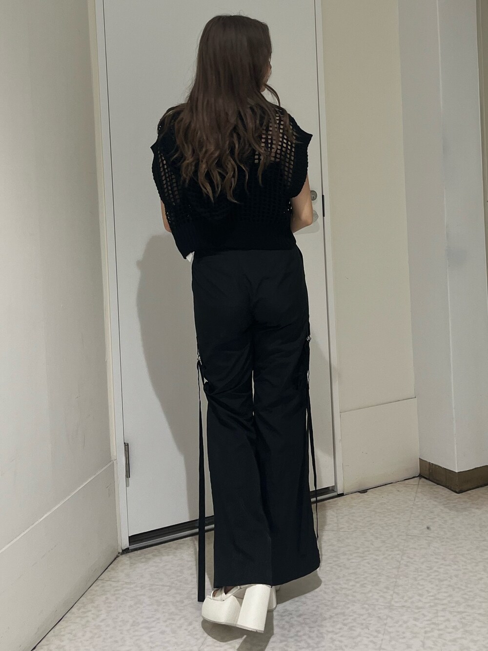 ブラック系のニット/セーター、ブラック系のキャミソール、ブラック系のカーゴパンツを着用したレディースの夏コーディネートの3枚目の写真